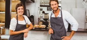 Happy servers smiling at camera at the coffee shop