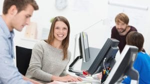 Smiling young businesswoman in a busy office